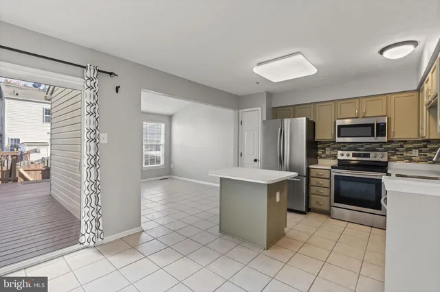 a kitchen with white cabinets and appliances