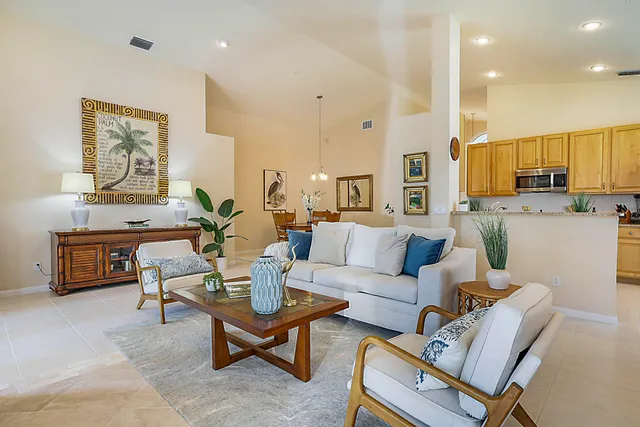 a living room with furniture a potted plant and a wooden floor