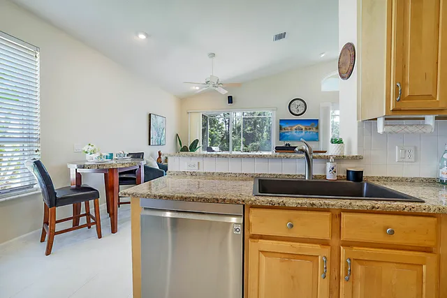 a kitchen with sink a refrigerator and chairs
