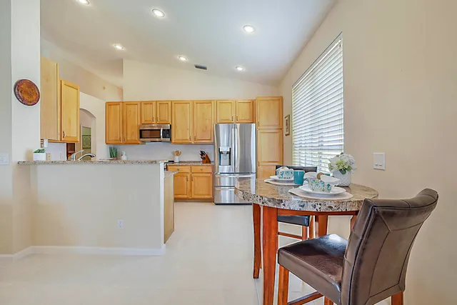 a kitchen with stainless steel appliances granite countertop a stove a sink and a refrigerator