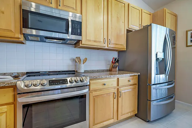 a kitchen with stainless steel appliances granite countertop a stove a sink and a microwave