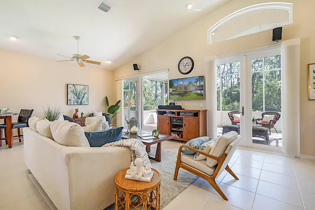 a living room with furniture a clock on wall and a window