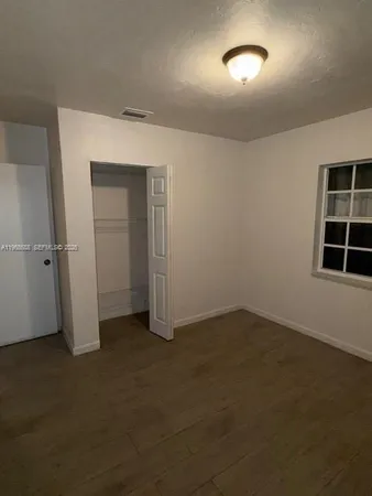 an empty room with closet and windows