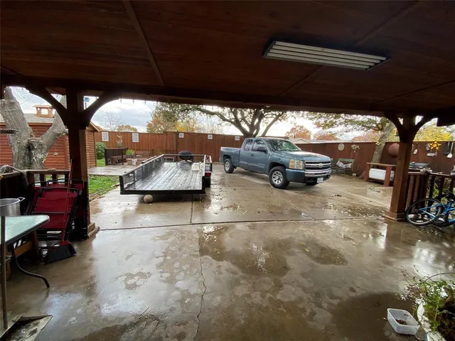 a backyard of a house with table and chairs and potted plants