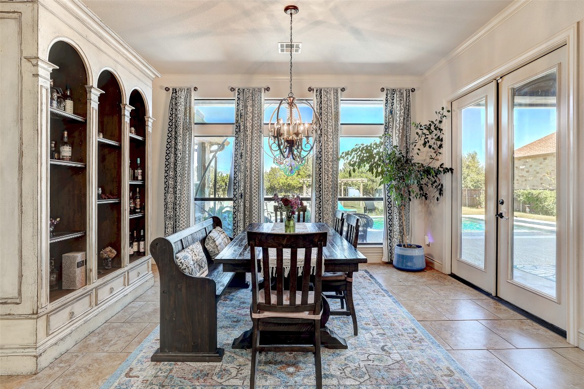 Undisclosed Address Georgetown, TX 78633 - Photo 14 of 38 Dining room featuring french doors, ornamental molding, a chandelier, and light tile patterned floors