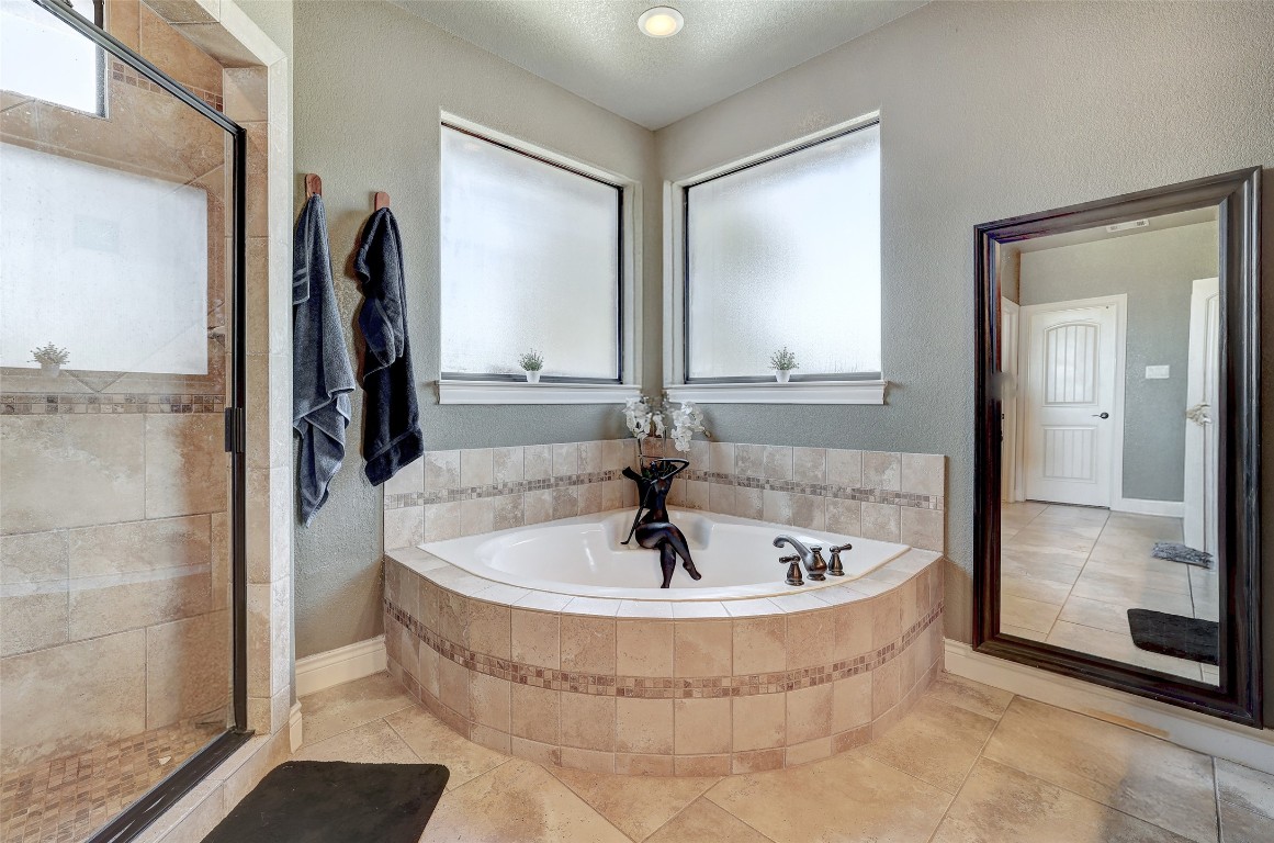 Undisclosed Address Georgetown, TX 78633 - Photo 22 of 38 Bathroom with a bath, a stall shower, a textured wall, and tile patterned floors