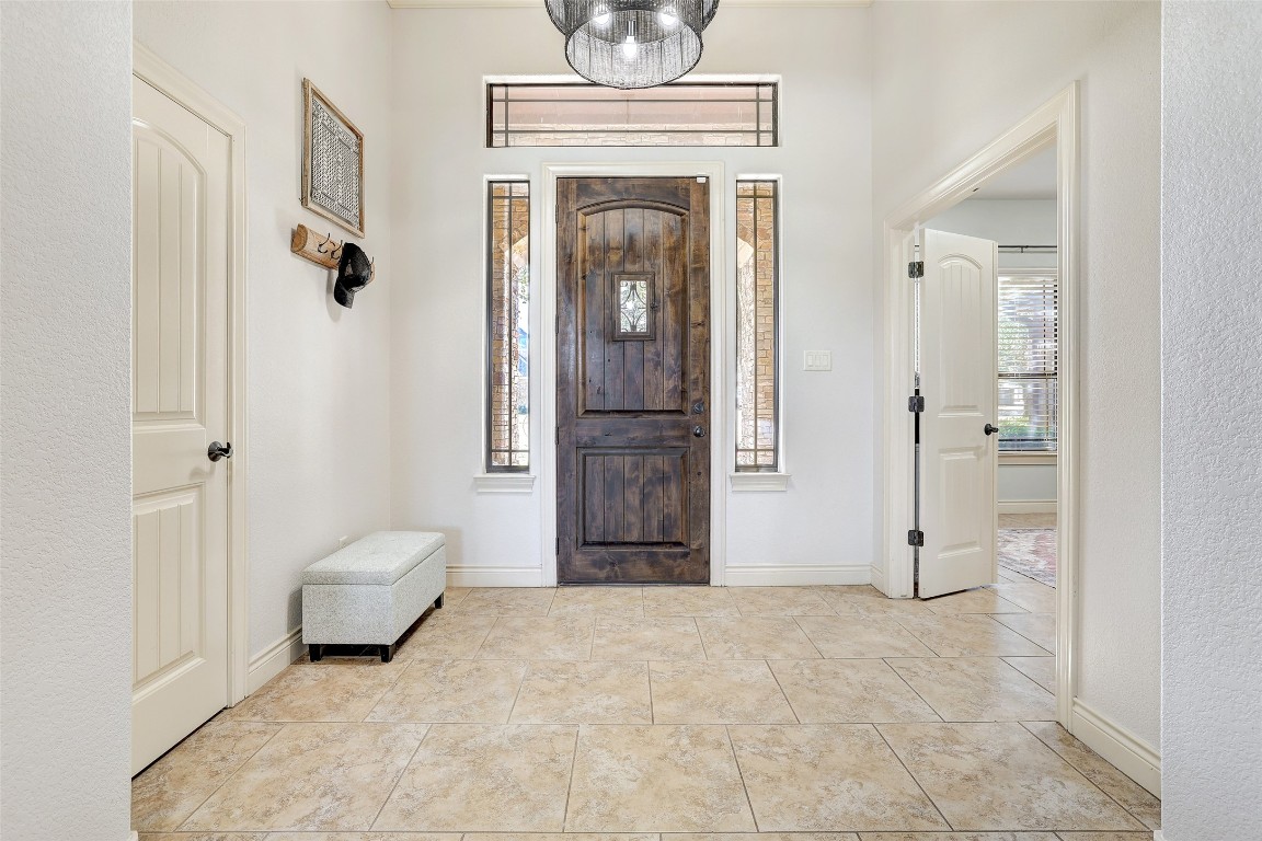 Undisclosed Address Georgetown, TX 78633 - Photo 7 of 38 Entrance foyer with light tile patterned floors and a chandelier