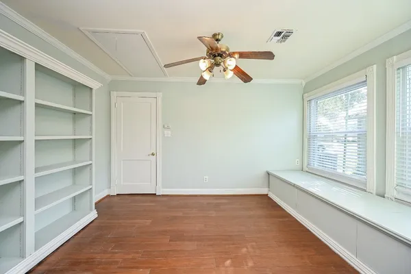 a view of an empty room with window and wooden floor