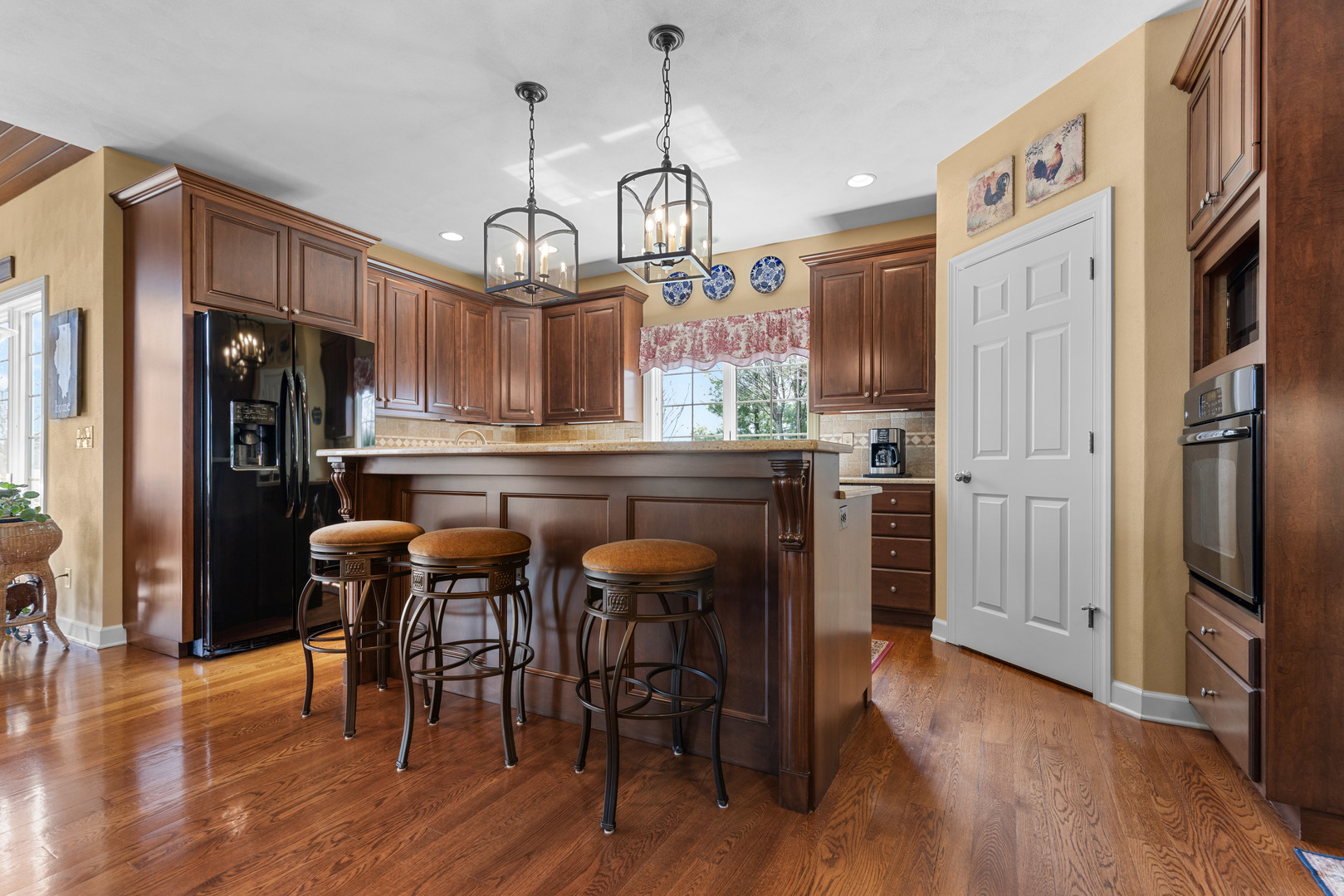 10125 Creek Ridge Trail Belvidere, IL 61008 - Photo 6 of 41 a kitchen with stainless steel appliances granite countertop a refrigerator a microwave a stove and island with wooden floor