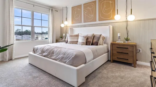 a living room with a bed furniture and next to a window