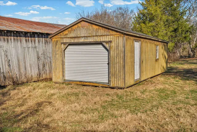 a view of a dry yard with wooden fence