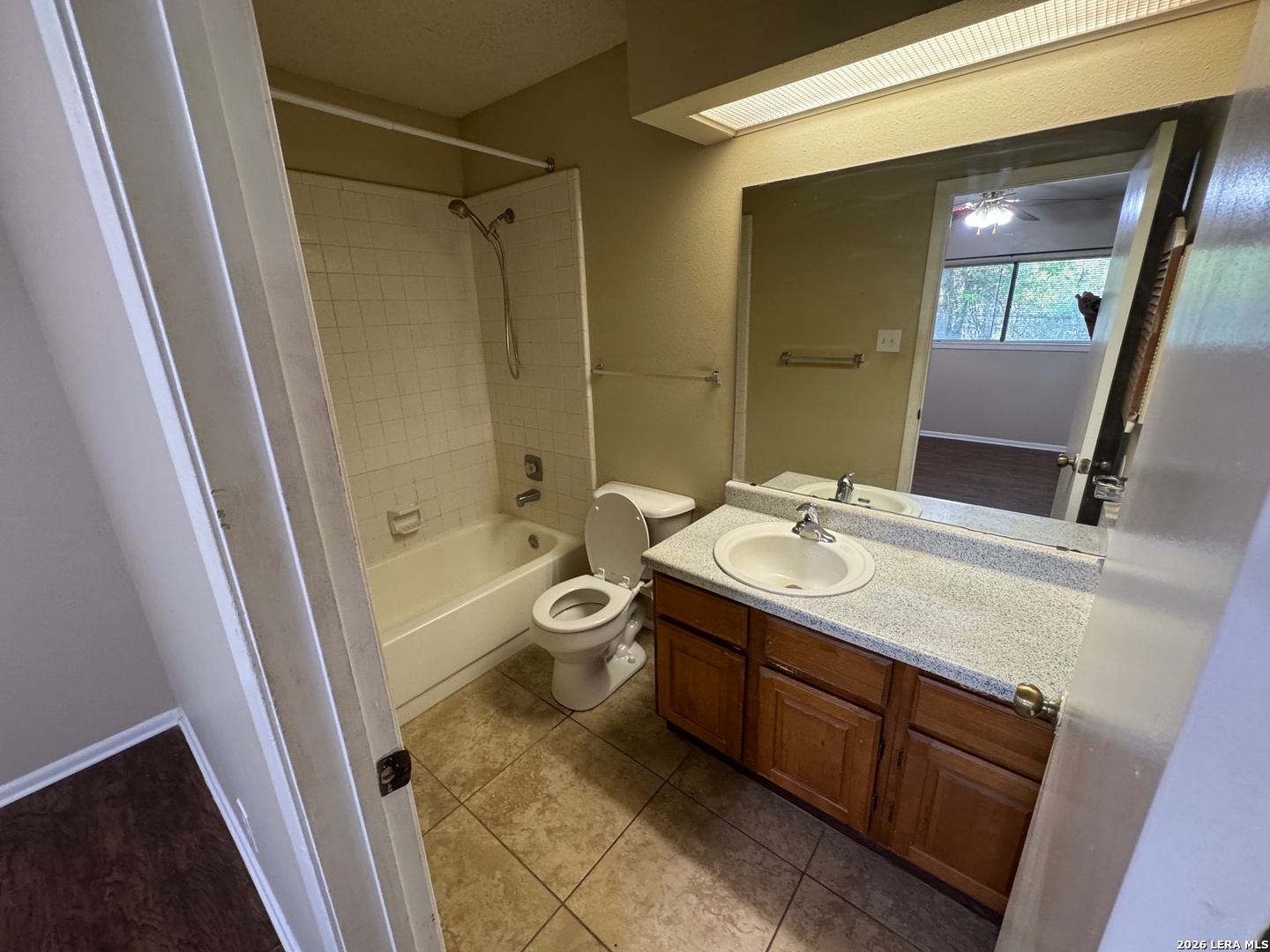 7236 Rimwood Street San Antonio, TX 78233 - Photo 12 of 16 a bathroom with a sink a toilet a mirror and shower