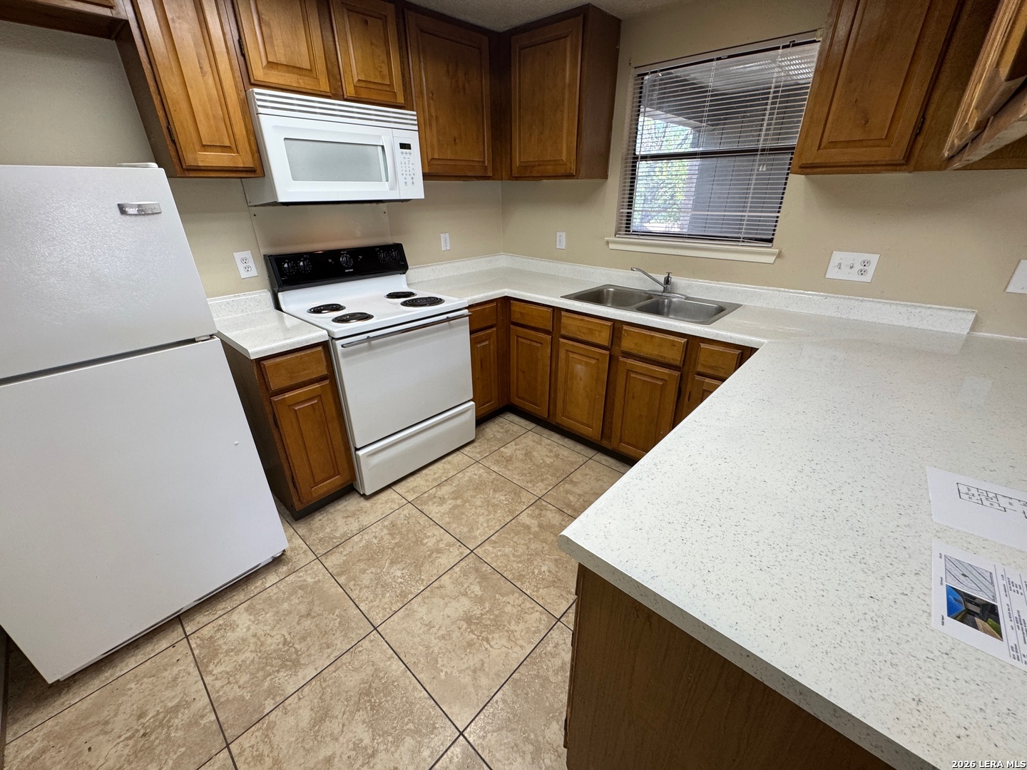 7236 Rimwood Street San Antonio, TX 78233 - Photo 9 of 16 a kitchen with a sink a stove top oven a refrigerator and cabinets