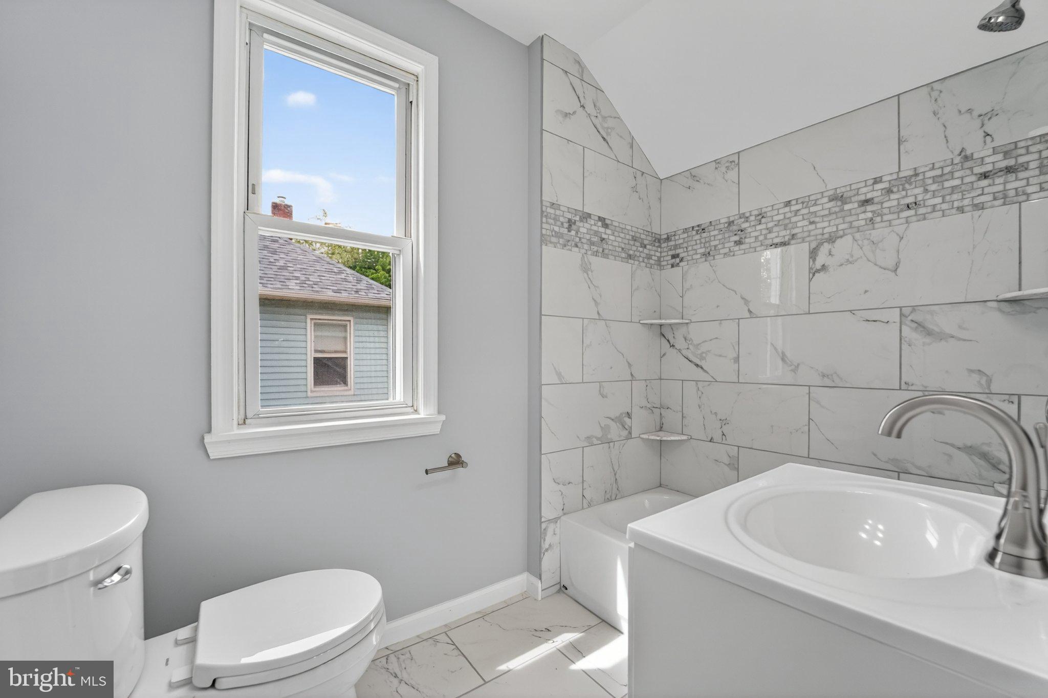 5312 Catalpha Road Baltimore, MD 21214 - Photo 25 of 59 a bathroom with a sink a toilet and shower