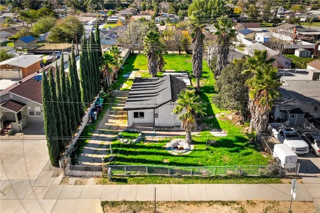 a view of a house with a yard and potted plants
