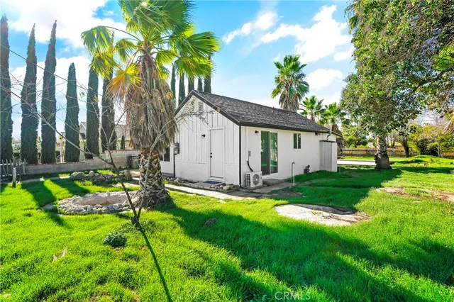 a front view of a house with a yard and potted plants