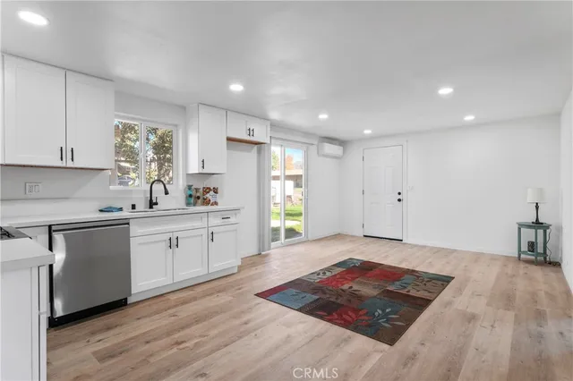 a kitchen with a sink wooden floor cabinets and a window