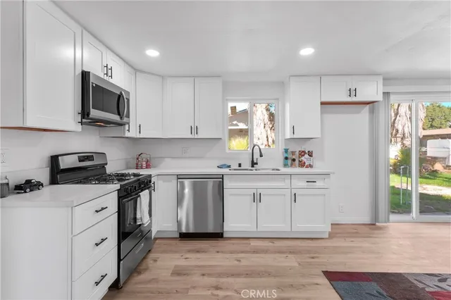 a kitchen with stainless steel appliances granite countertop a stove a sink and a refrigerator