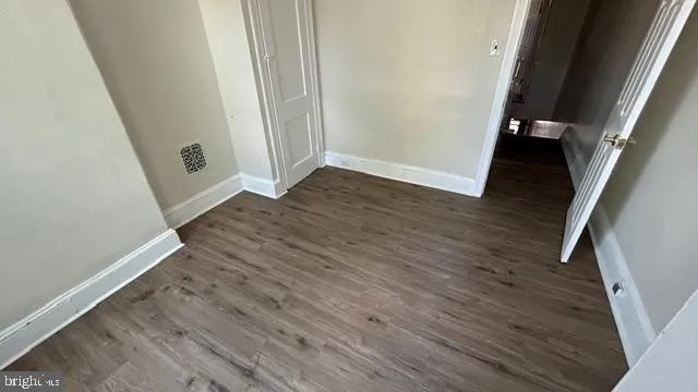 an empty room with wooden floor and entrance