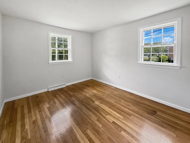 a view of a room with wooden floor and windows