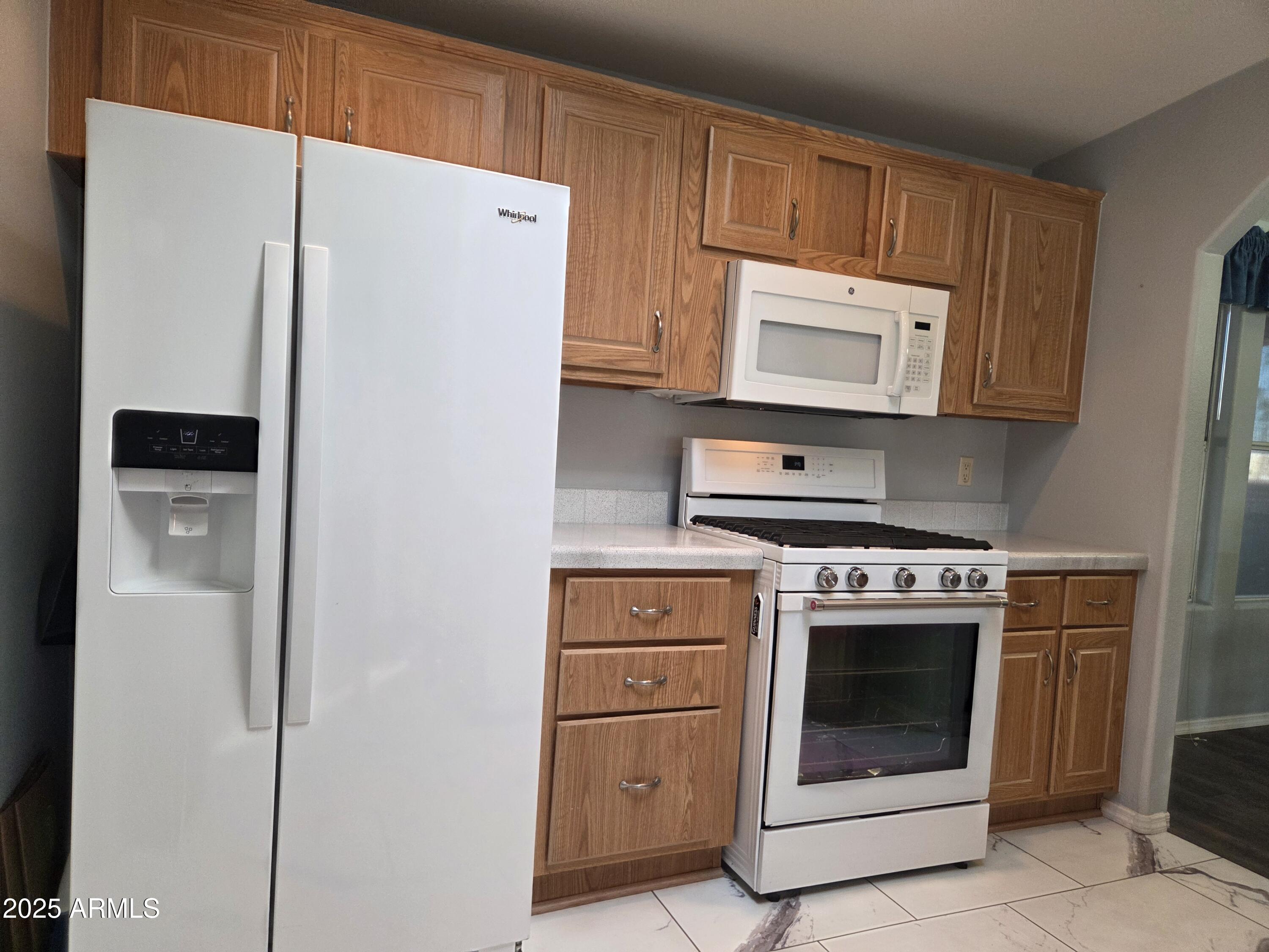 2929 East Main Street, Unit 107 Mesa, AZ 85213 - Photo 14 of 42 a kitchen with cabinets and a refrigerator