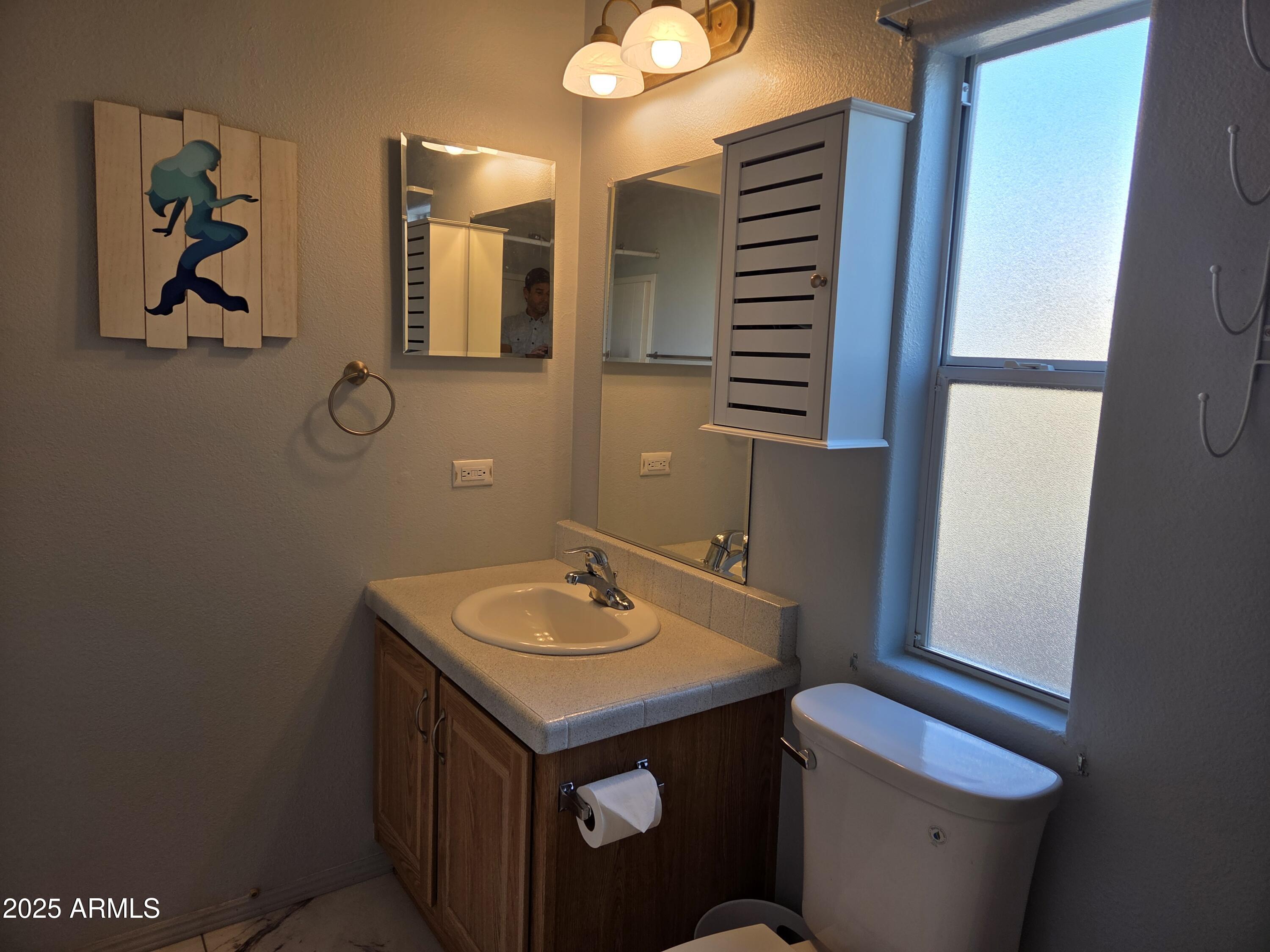2929 East Main Street, Unit 107 Mesa, AZ 85213 - Photo 28 of 42 a bathroom with a sink a toilet and mirror