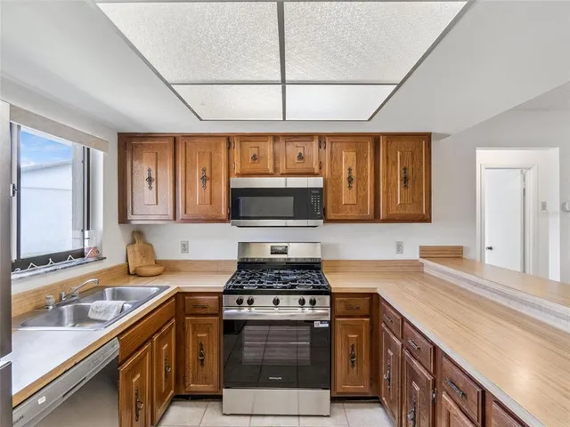 a kitchen with stainless steel appliances granite countertop a sink stove and cabinets