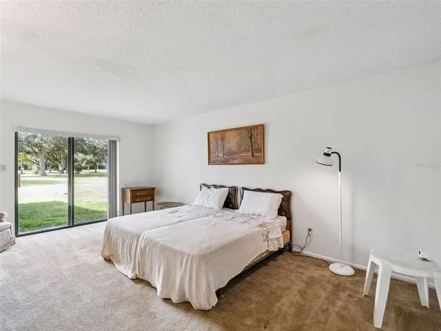 a spacious bedroom with a bed and a dresser