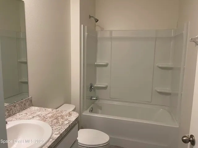 a bathroom with a granite countertop toilet sink and shower