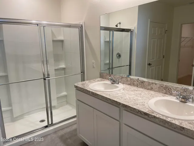 a bathroom with a granite countertop sink mirror and shower