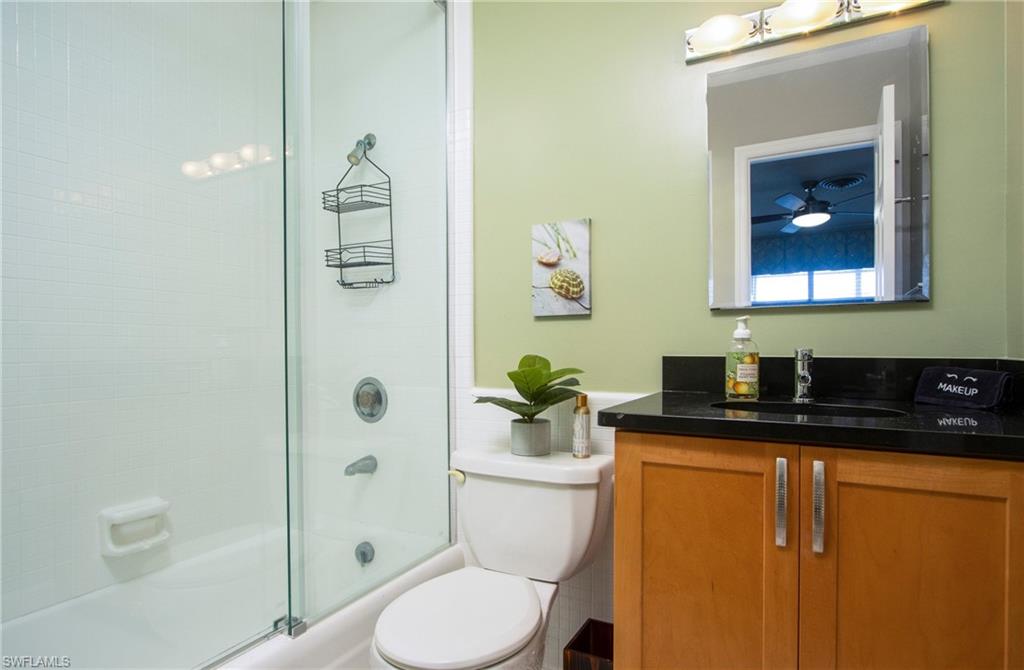 820 Ketch Drive, Unit 8 Naples, FL 34103 - Photo 16 of 16 a bathroom with a granite countertop toilet sink and mirror