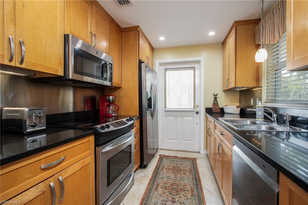820 Ketch Drive, Unit 8 Naples, FL 34103 - Photo 8 of 16 a kitchen with stainless steel appliances granite countertop a stove a sink and a microwave