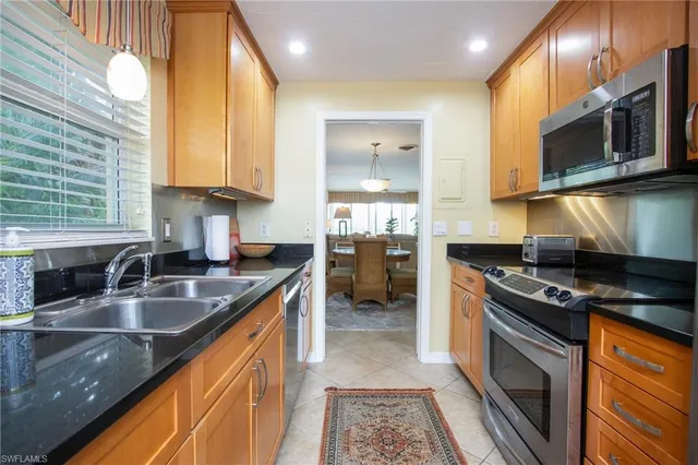 a kitchen with stainless steel appliances granite countertop a sink a stove oven and granite counter tops