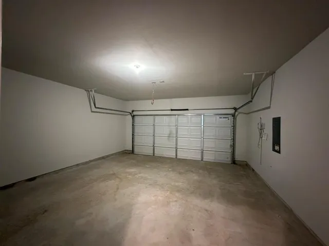 an empty room with white cabinet and windows