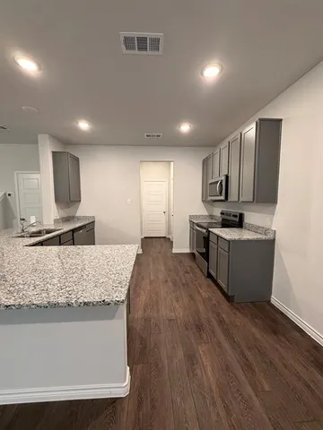 a kitchen with stainless steel appliances granite countertop a sink stove and refrigerator