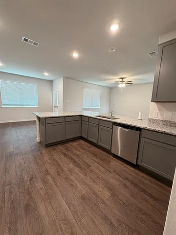 a large kitchen with wooden floors and stainless steel appliances