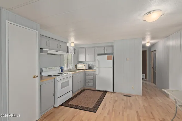 a kitchen with a sink a refrigerator and cabinets