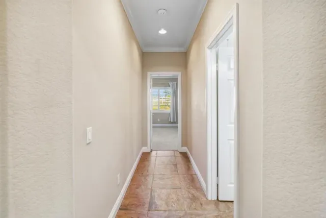 a view of a hallway with wooden floor and a bathroom