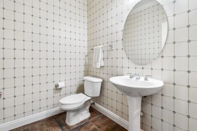 a bathroom with a toilet sink and mirror