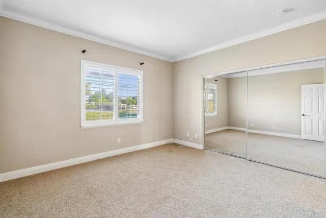 an empty room with windows and closet