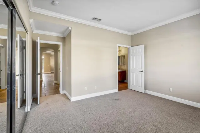 a view of an empty room with closet and a window