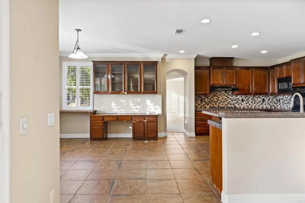 13371 Sage Meadow Lane, Unit 1 Valley Center, CA 92082 - Photo 23 of 38 a kitchen with granite countertop a stove and a refrigerator