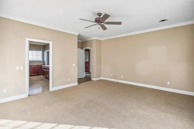 a view of an empty room with a ceiling fan
