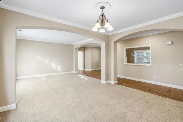 a view of a livingroom with a chandelier fan and windows