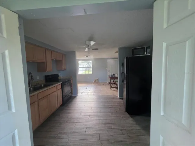 a large kitchen with a refrigerator and a stove top oven