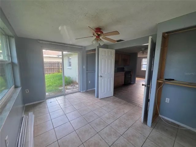 a view of a livingroom with a chandelier fan and windows
