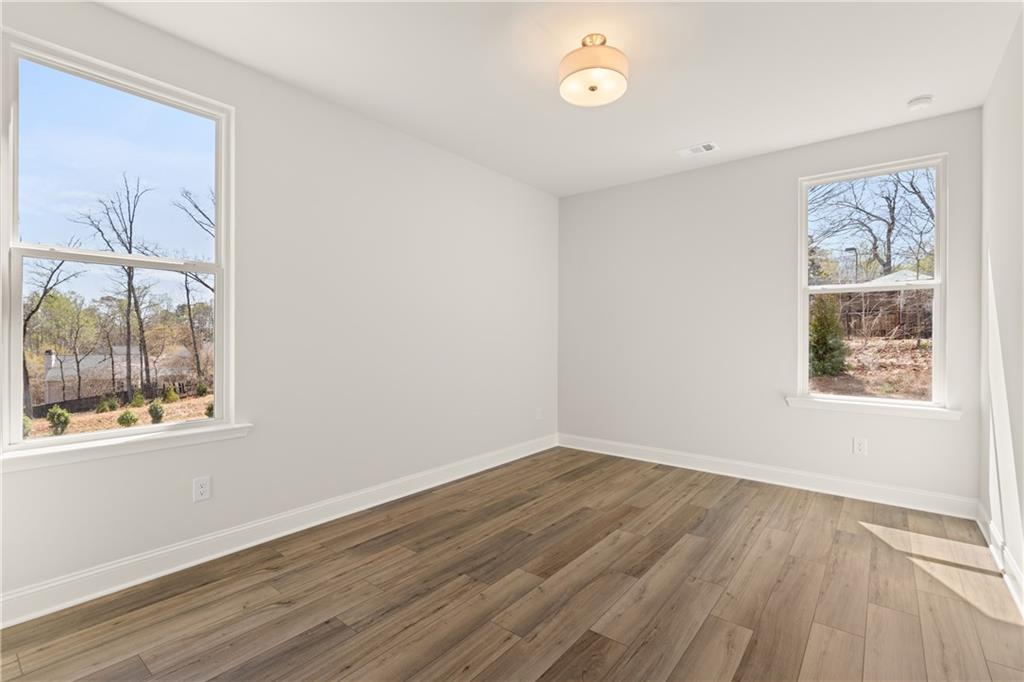 900 Melody Ridge Lane Buford, GA 30518 - Photo 16 of 30 an empty room with wooden floor and windows