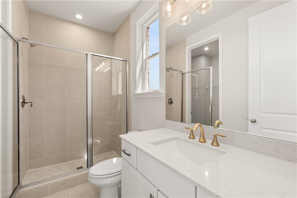900 Melody Ridge Lane Buford, GA 30518 - Photo 17 of 30 a bathroom with a granite countertop sink toilet and shower