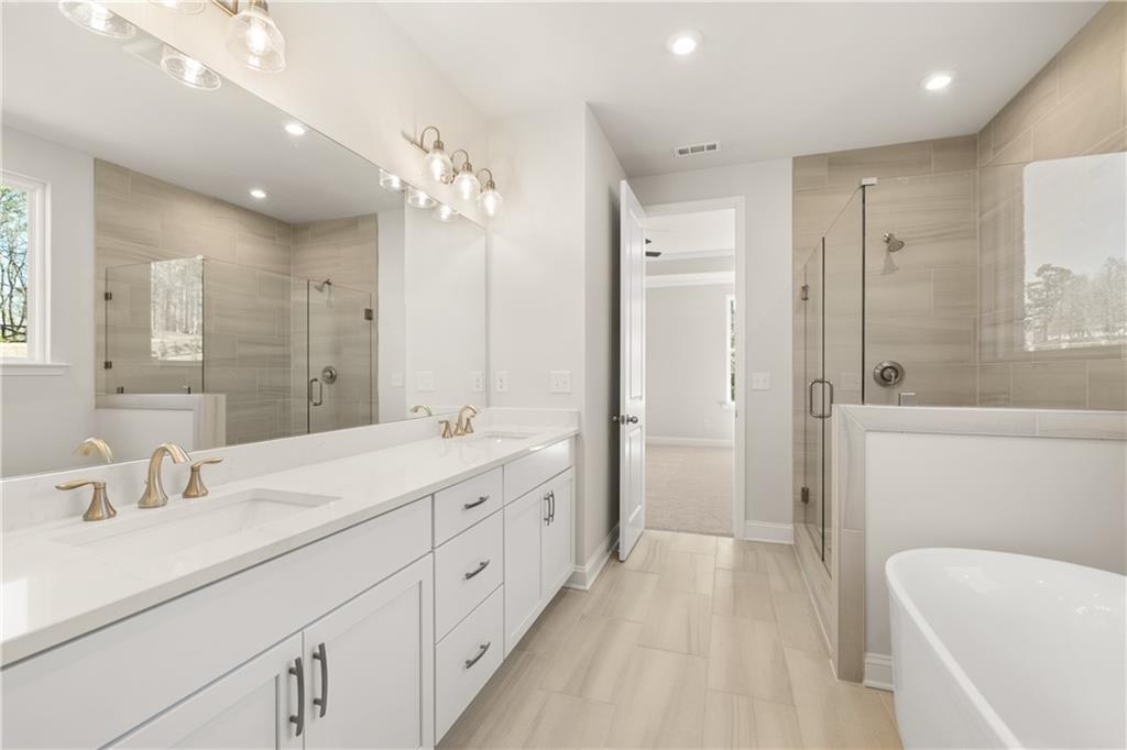 900 Melody Ridge Lane Buford, GA 30518 - Photo 22 of 30 a spacious bathroom with a double vanity sink mirror double and shower