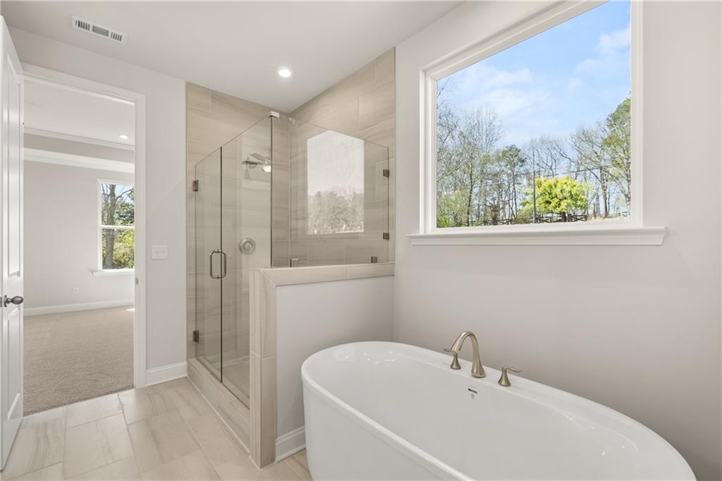 900 Melody Ridge Lane Buford, GA 30518 - Photo 23 of 30 a bathroom with a bathtub and a shower